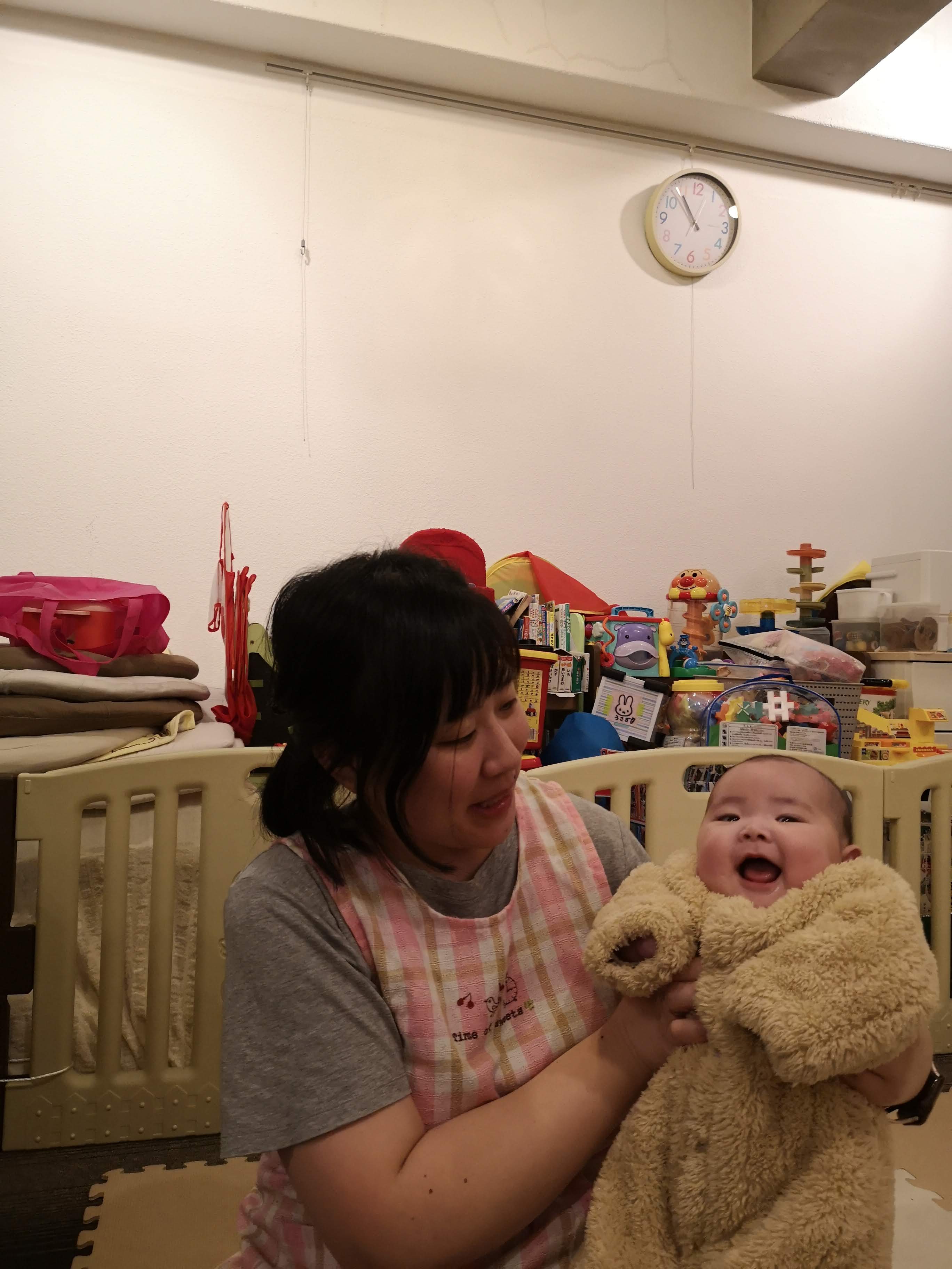 赤ちゃんを抱き笑顔を引き出す保育士